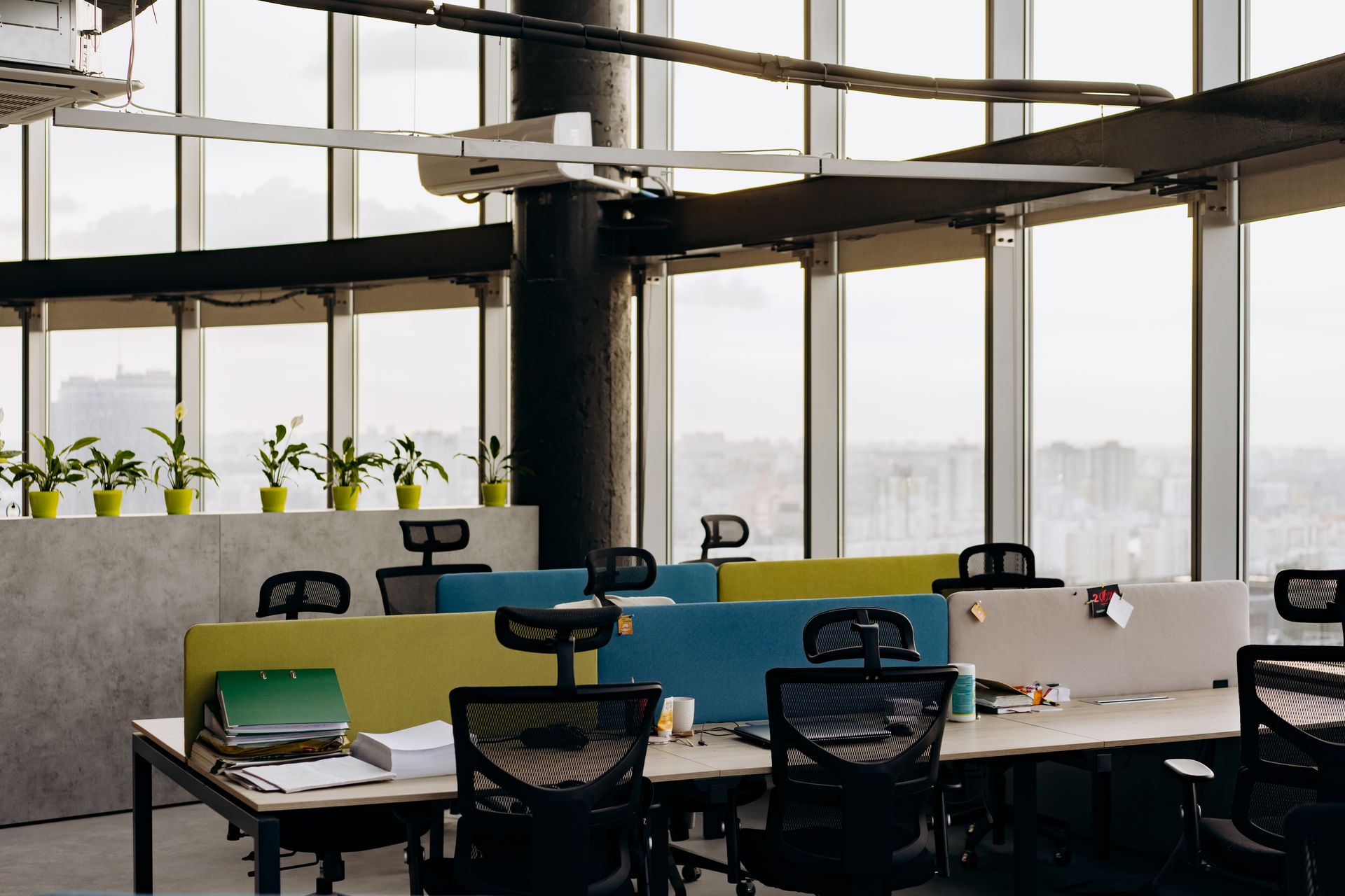 Modern office desks against a full-height city-view window